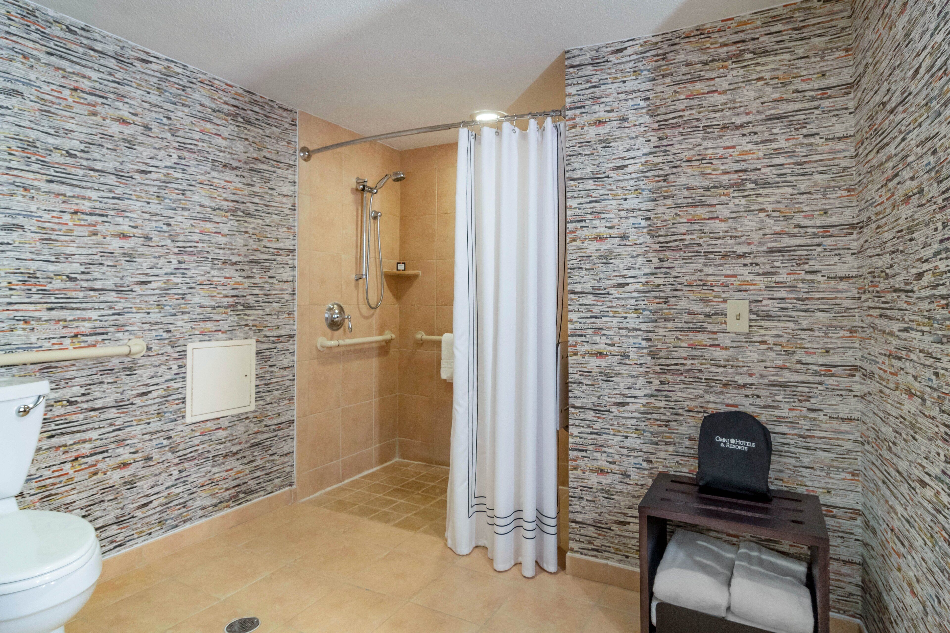 Une salle de bain équipée d’une douche, de toilettes et d’un porte-serviettes.