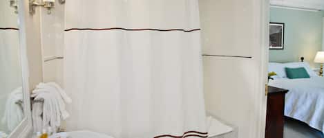 Een badkamer met een wit wastafel, een spiegel en een douchegordijn.