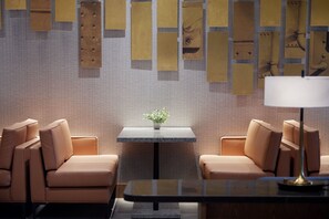 Relax in a serene space with plush armchairs and a geometric-patterned wall.