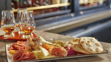 A charcuterie board with various meats, cheeses, and crackers on a marble table.
