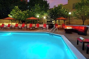 Una piscina al aire libre de temporada, sombrillas