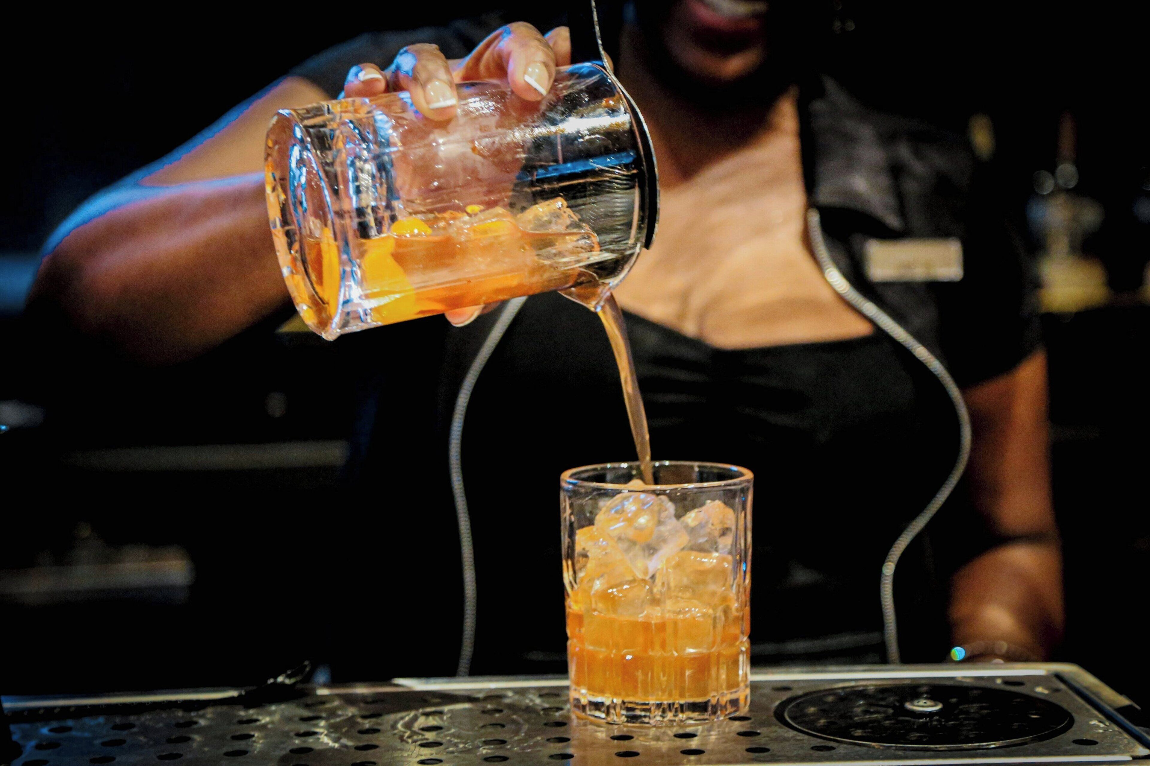 A person pouring a drink into a glass.