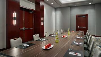 A conference room with a long table, chairs, and a door.