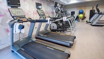 Et fitnessrum med flere løbebånd, motionscykler og træningsbolde.