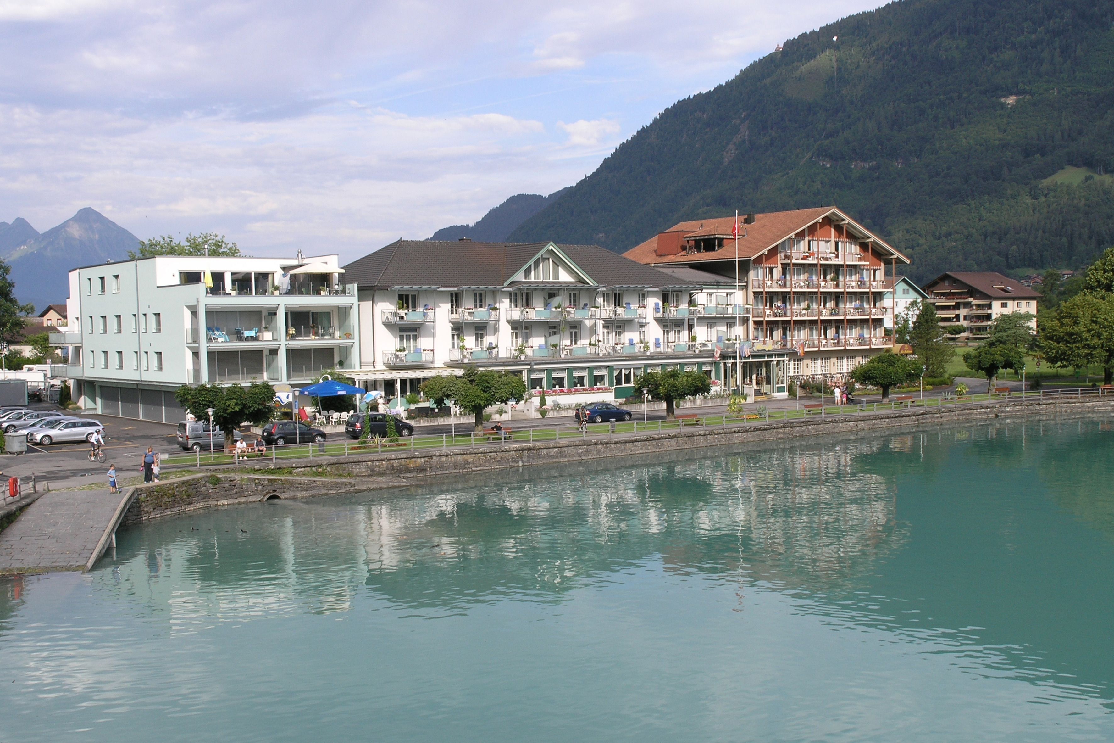 Un hôtel à étages, offrant une vue sur le front de mer et adossé à une chaîne de montagnes.