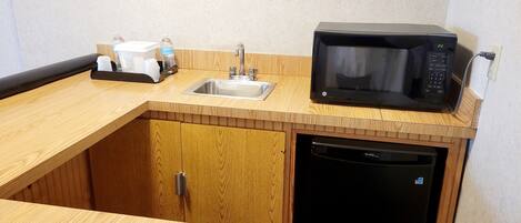 A compact kitchen with a sink, microwave, and dishwasher.