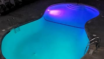 Une piscine intérieure au design incurvé, avec une échelle sur l’un des côtés.