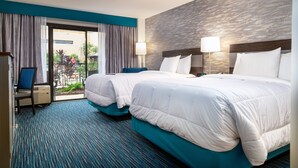 A hotel room with two beds, a view of the outdoors, and a blue carpet. - MCM Eleganté Hotel & Conference Center Beaumont (Beaumont)