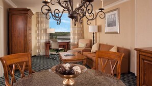 A well-furnished living room with a chandelier, wooden furniture, and a view through a window.