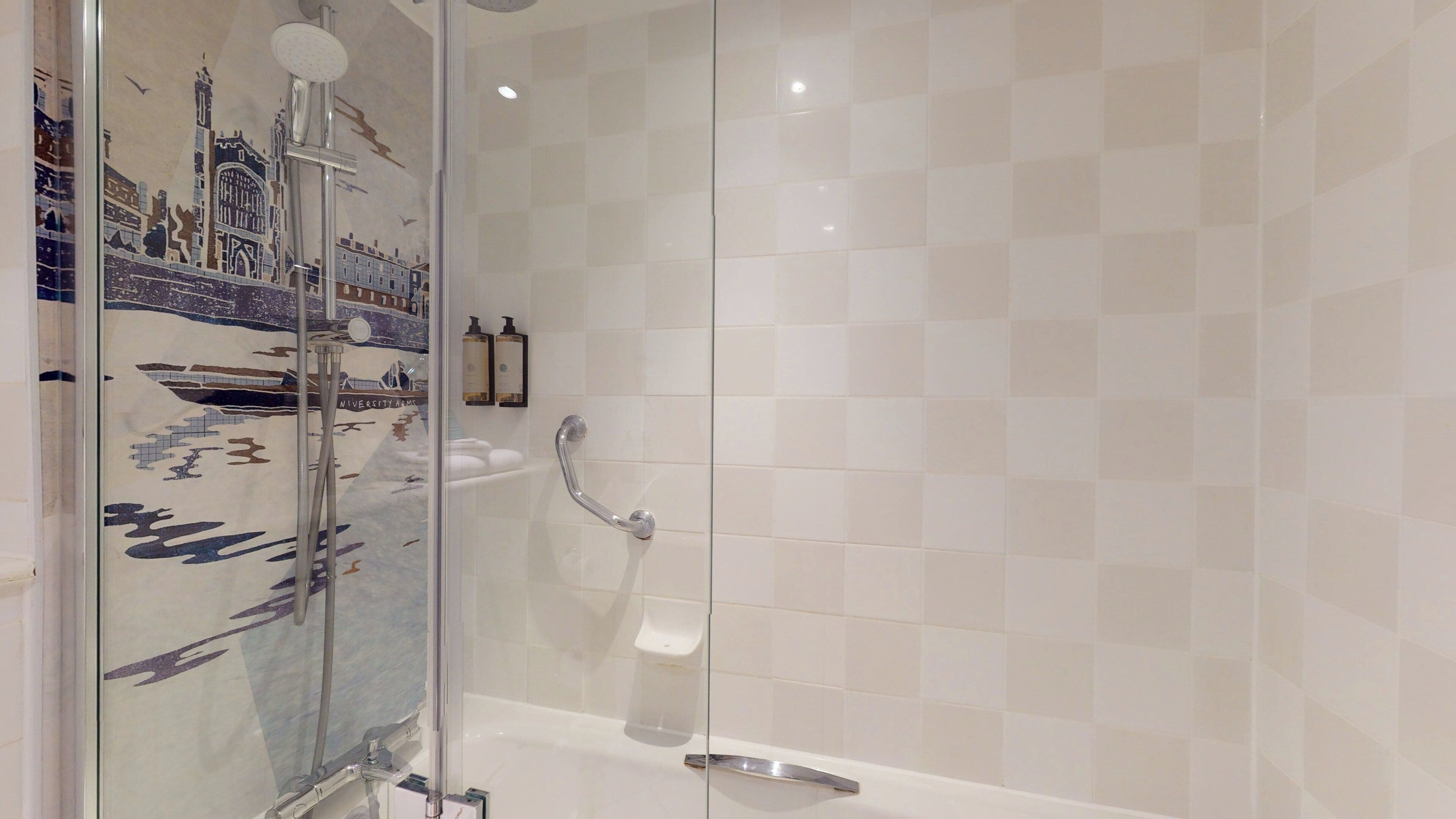 A bathroom with a glass shower enclosure, a bathtub, and a tiled wall.