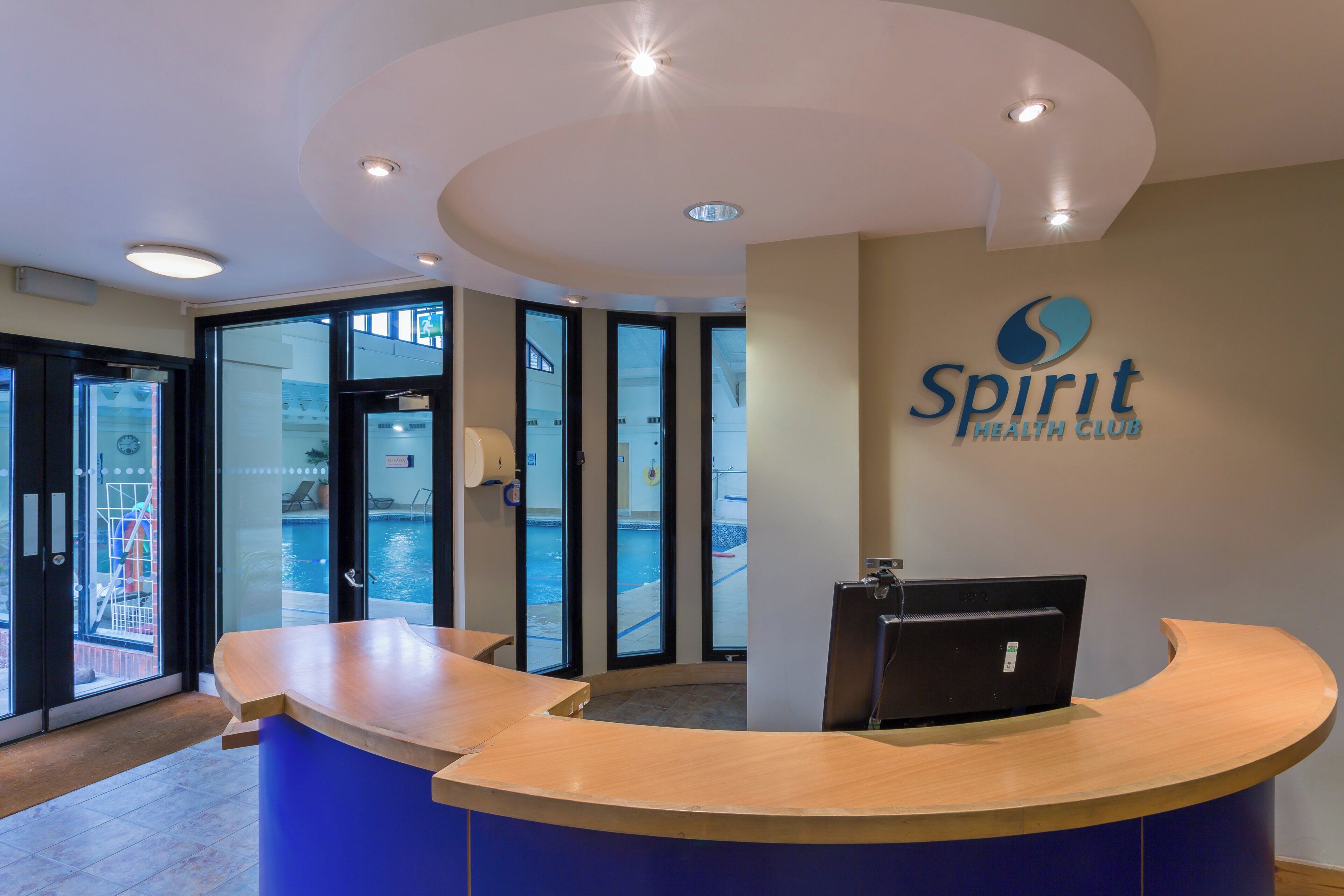A reception desk with a logo for 'Spirit Health Club' on the wall.