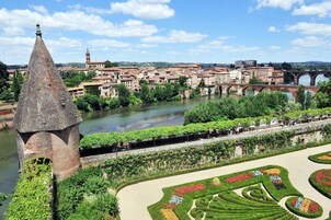 A historic town with a river, a tower, and a bridge.