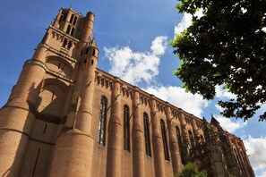 Un edificio grande e histórico con altas torres cilíndricas y ventanas en arco.