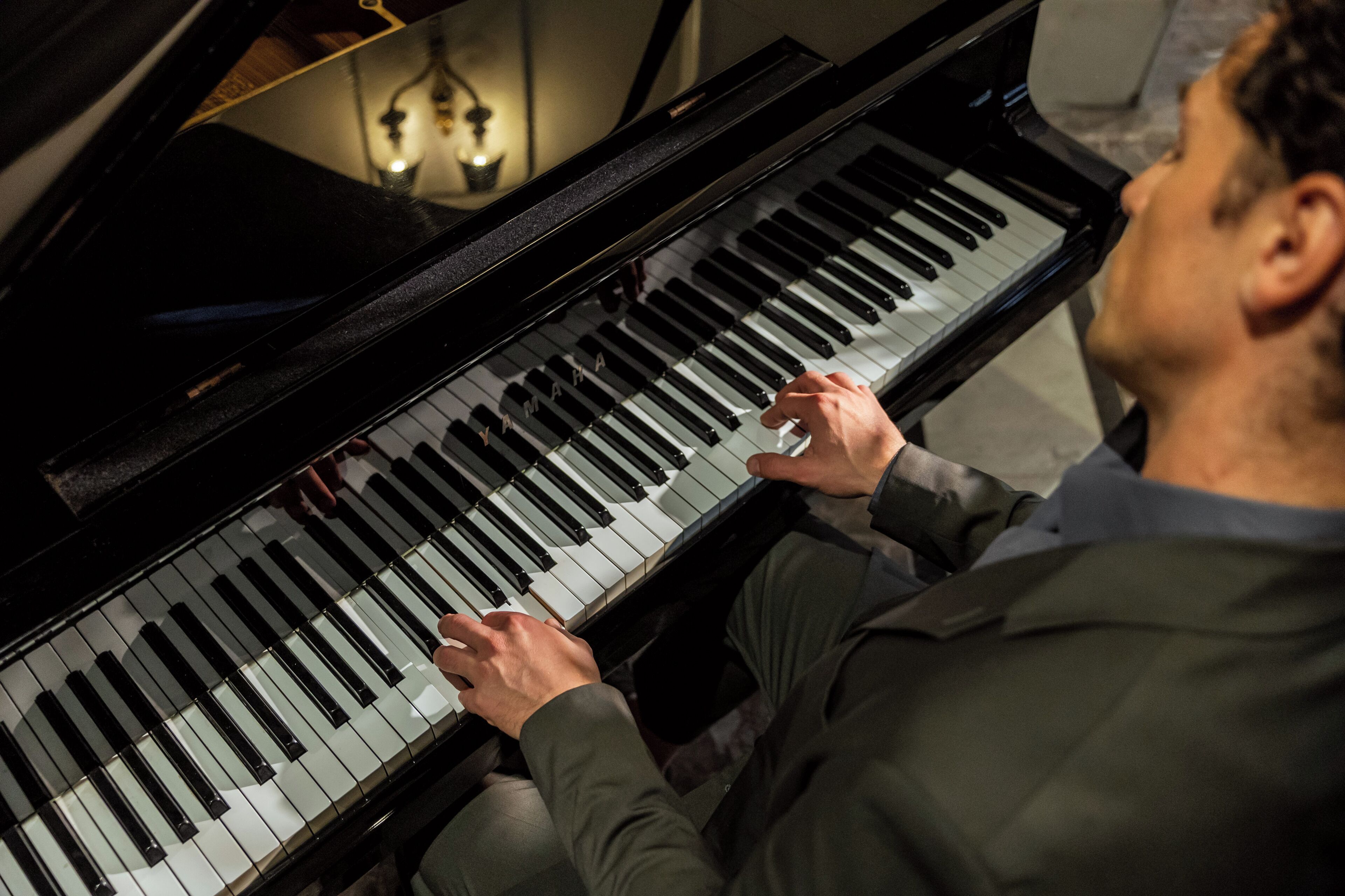 Uma pessoa tocando um piano preto.