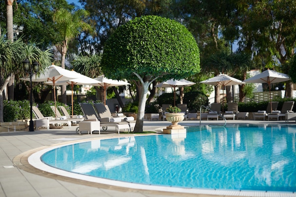 Una piscina techada, una piscina al aire libre de temporada, sombrillas