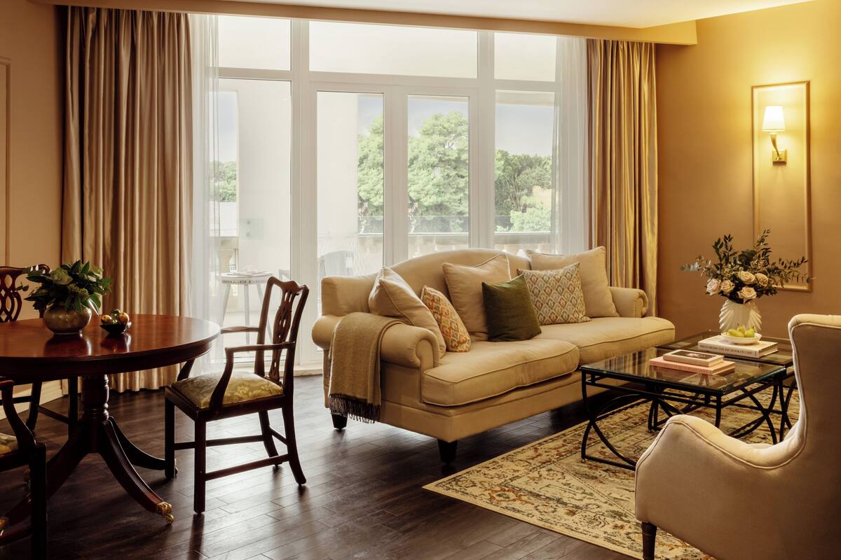A living room with a beige sofa, a wooden dining table, and a coffee table.