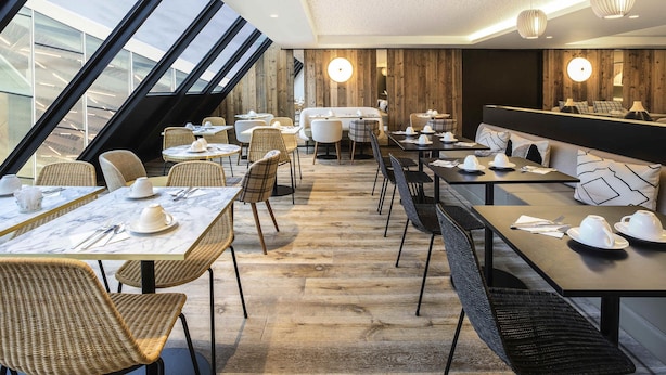 A modern restaurant with high ceilings, large windows, and a mix of seating styles including tables and booths. - Mercure Chambery Centre (Chambery)