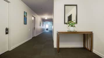 A hallway with a wooden console table, a mirror, and a door with a 'Please Do Not Disturb' sign.