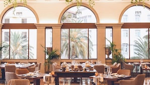 A spacious dining area with large windows, elegant table settings, and a warm color palette.