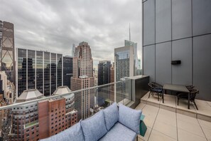 Ein Hochhaus mit Glasbalkon und Blick auf die Stadtlandschaft.