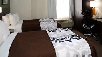 Habitación de hotel con dos camas, un escritorio, una silla, un equipo de aire acondicionado y una lámpara.