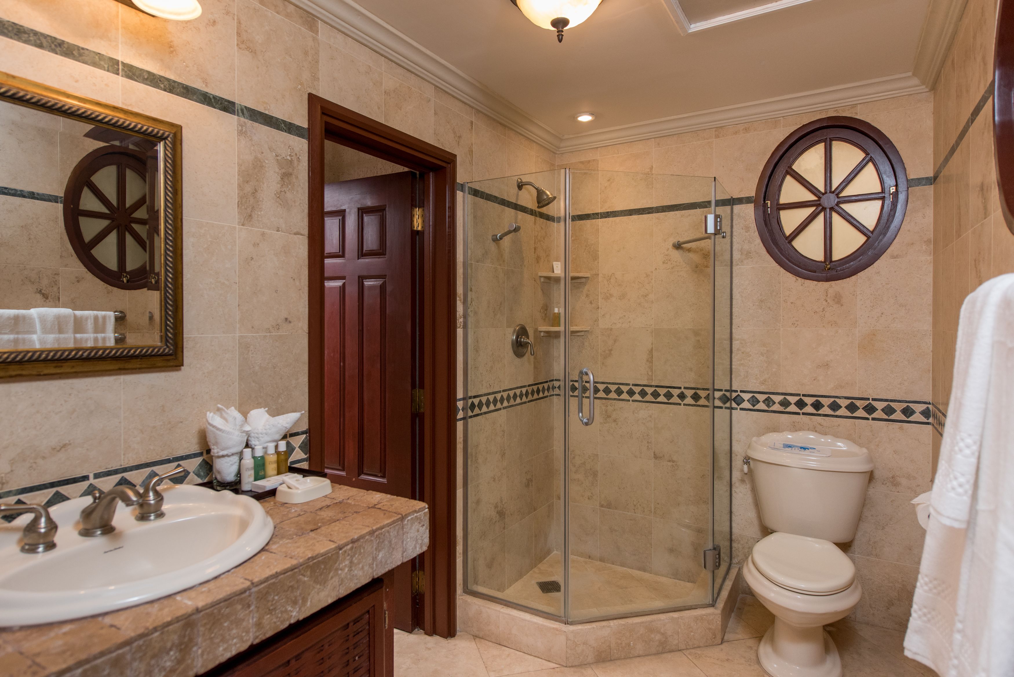 Un bagno con cabina doccia in vetro, un lavandino bianco e un water.