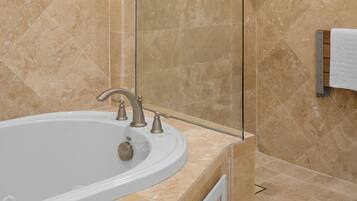 A bathroom with a bathtub, a sink, and a towel rack.