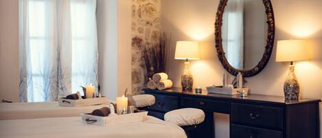 A hotel room with two beds, a dresser, a mirror, and two lamps.
