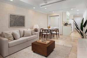 A modern living room with a sofa, coffee table, and dining area.