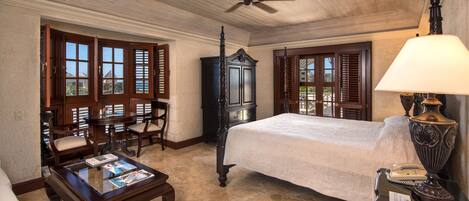 A bedroom with a bed, a desk, and a chair.