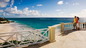 Une vue sur la côte, avec une balustrade blanche et un ciel bleu dégagé.