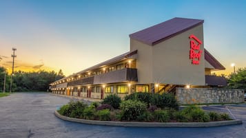 Et Red Roof Inn hotel med en toetages bygning, en stenfacade og en parkeringsplads.
