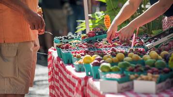 Un étal de marché où sont exposés divers fruits et légumes dans des caisses vertes.