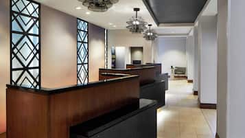 A reception area with a wooden reception desk, a decorative glass partition, and pendant lighting.