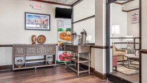 A lobby with a reception desk, a coffee station, a wall-mounted TV, and a 'No Smoking' sign. - Quality Inn Suwanee I-85 (Suwanee)