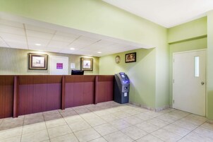 A reception area with a counter, a self-service kiosk, and a door.