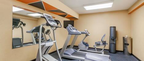 A gym with treadmills, a stationary bike, and a punching bag.