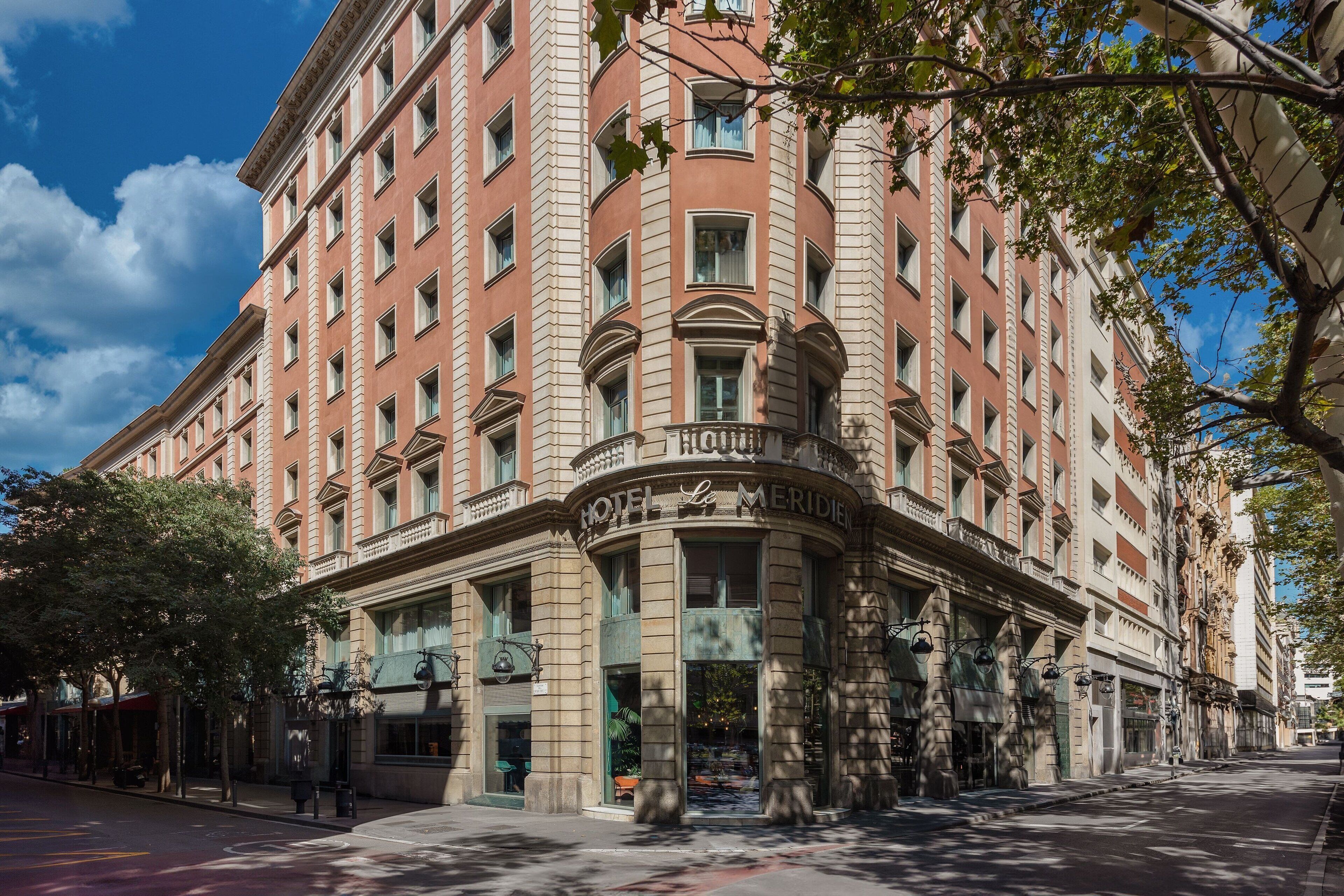 Un hotel histórico con una fachada clásica, ventanas amplias y una entrada destacada.