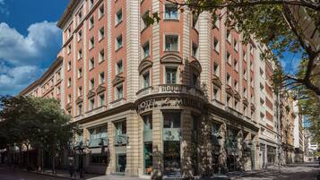 Un hotel histórico con una fachada clásica, ventanas amplias y una entrada destacada.
