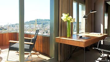 Un espacio de oficina moderno con un escritorio, una silla y vistas a un paisaje urbano a través de amplios ventanales.