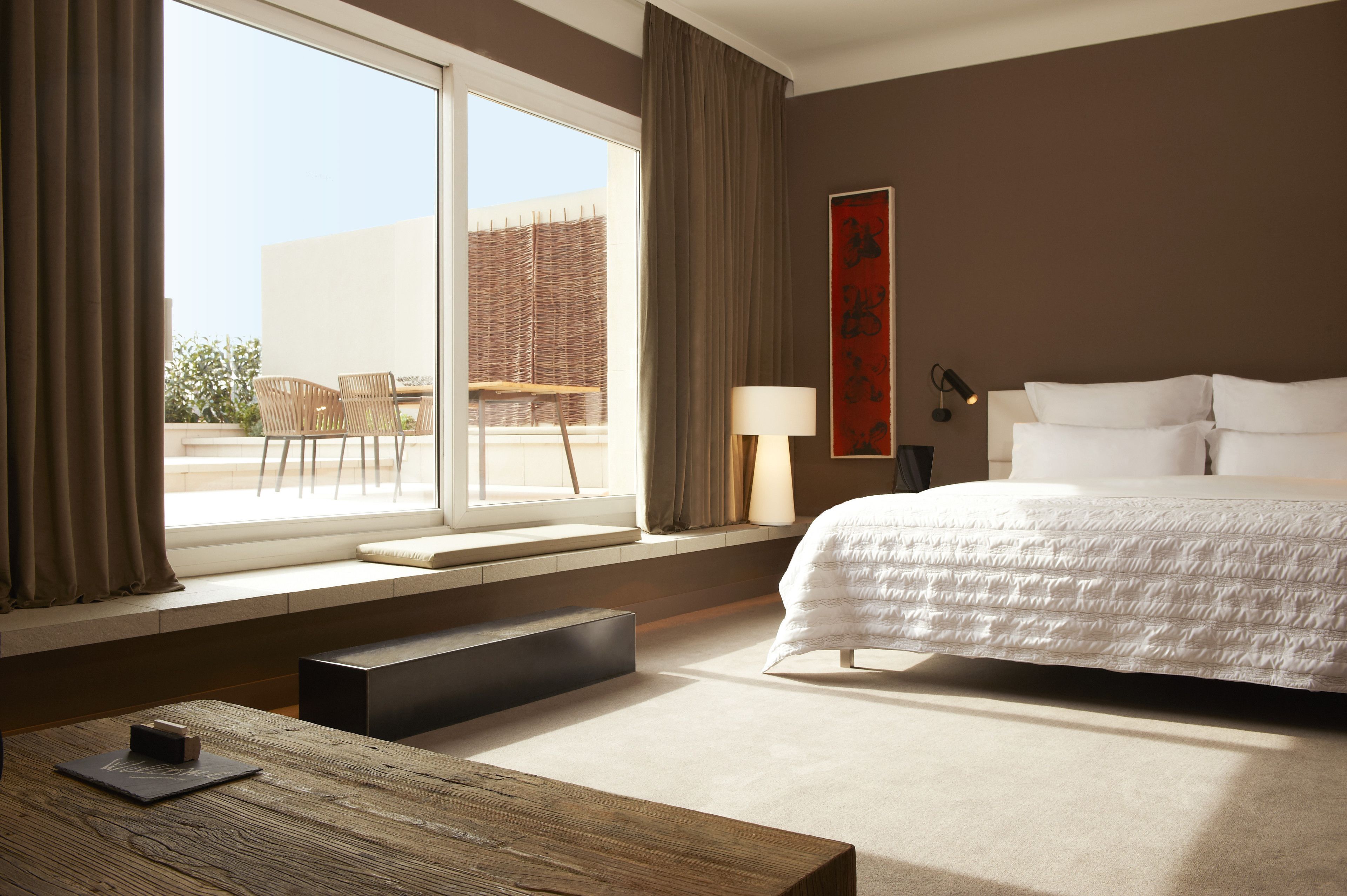 Ein Hotelzimmer mit einem großen Bett, einem Fenster mit Ausblick, einem Schreibtisch und einem Stuhl.