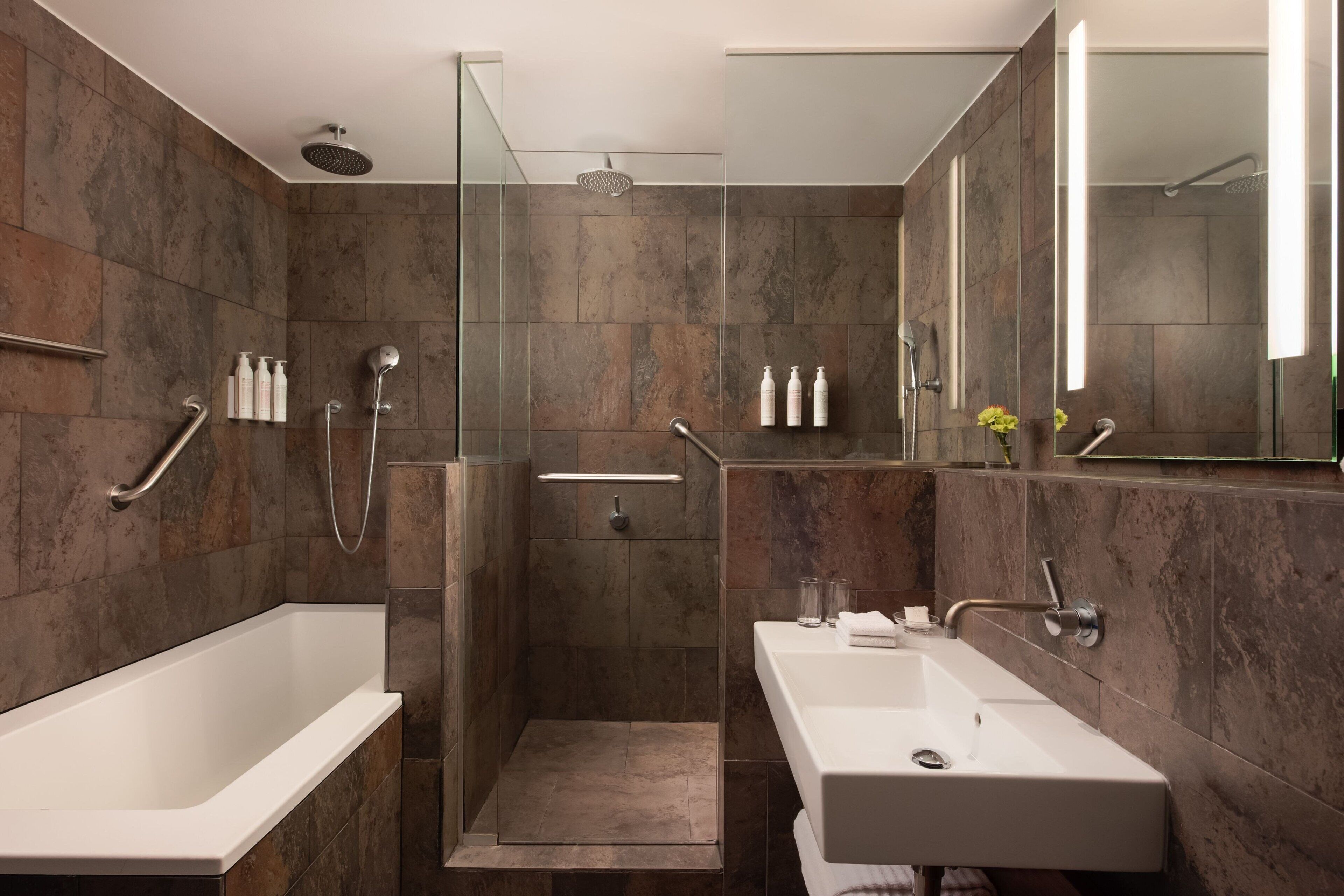 A modern bathroom with a walk-in shower, a bathtub, and a vanity with a sink.