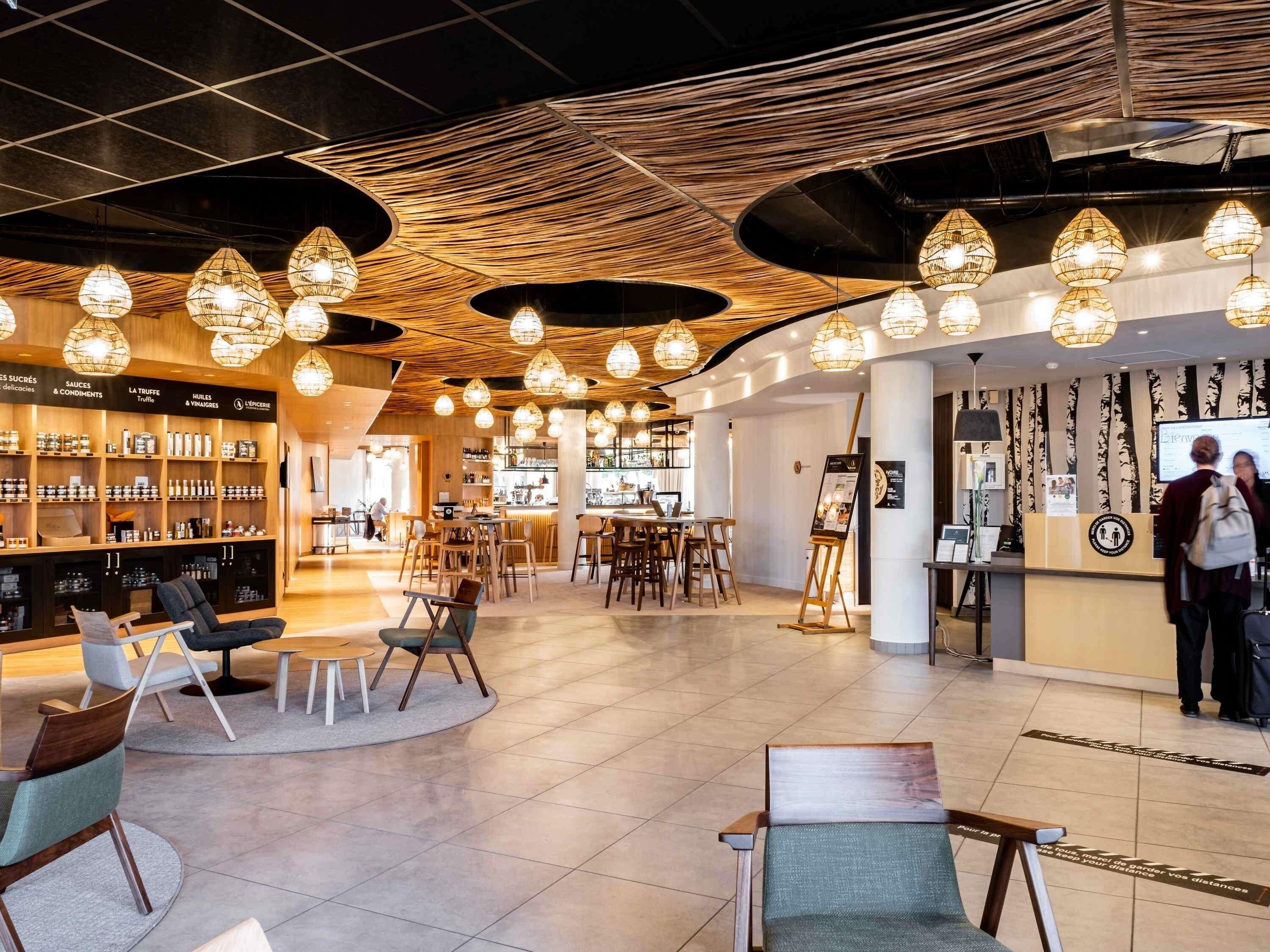Un interior moderno con una zona de bar, asientos y un mostrador de recepción.