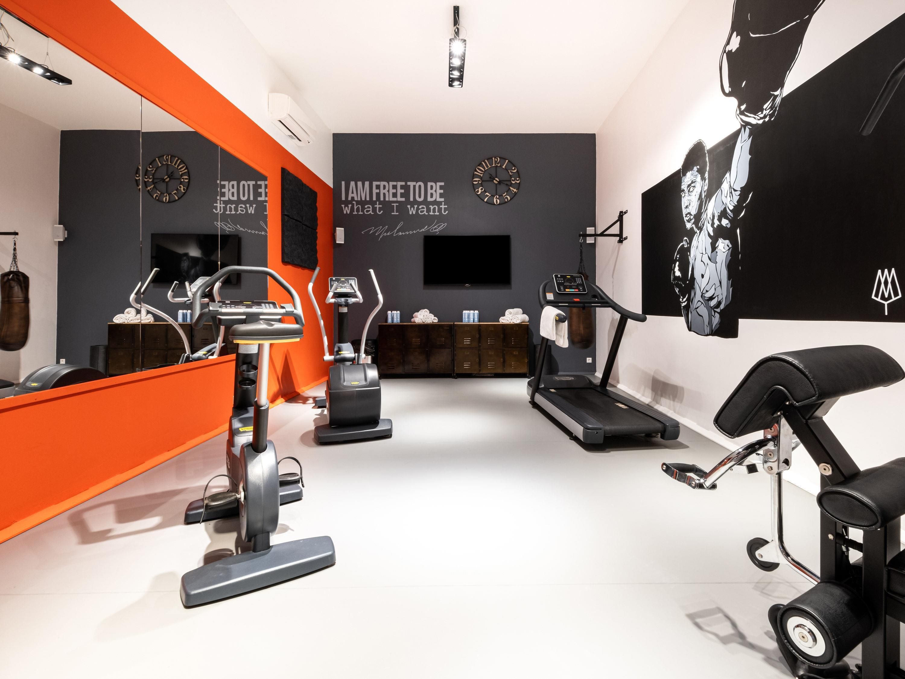 A modern gym with cardio machines, a treadmill, and a stationary bike.