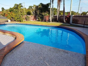 Una piscina al aire libre, tumbonas