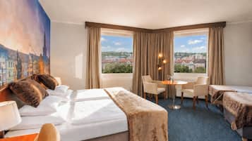 Une chambre d’hôtel avec un lit, deux chaises, une petite table et un tableau représentant un paysage urbain.