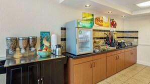 A self-service breakfast bar with a coffee machine, cereal dispensers, and a refrigerated display. - Quality Inn & Suites NRG Park - Medical Center (Houston)