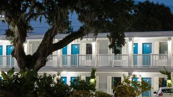 Ein zweistöckiges Motel mit blauen Türen und weißen Geländern.