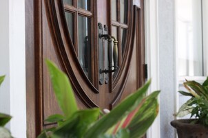 A wooden door with a glass panel and a brass handle.