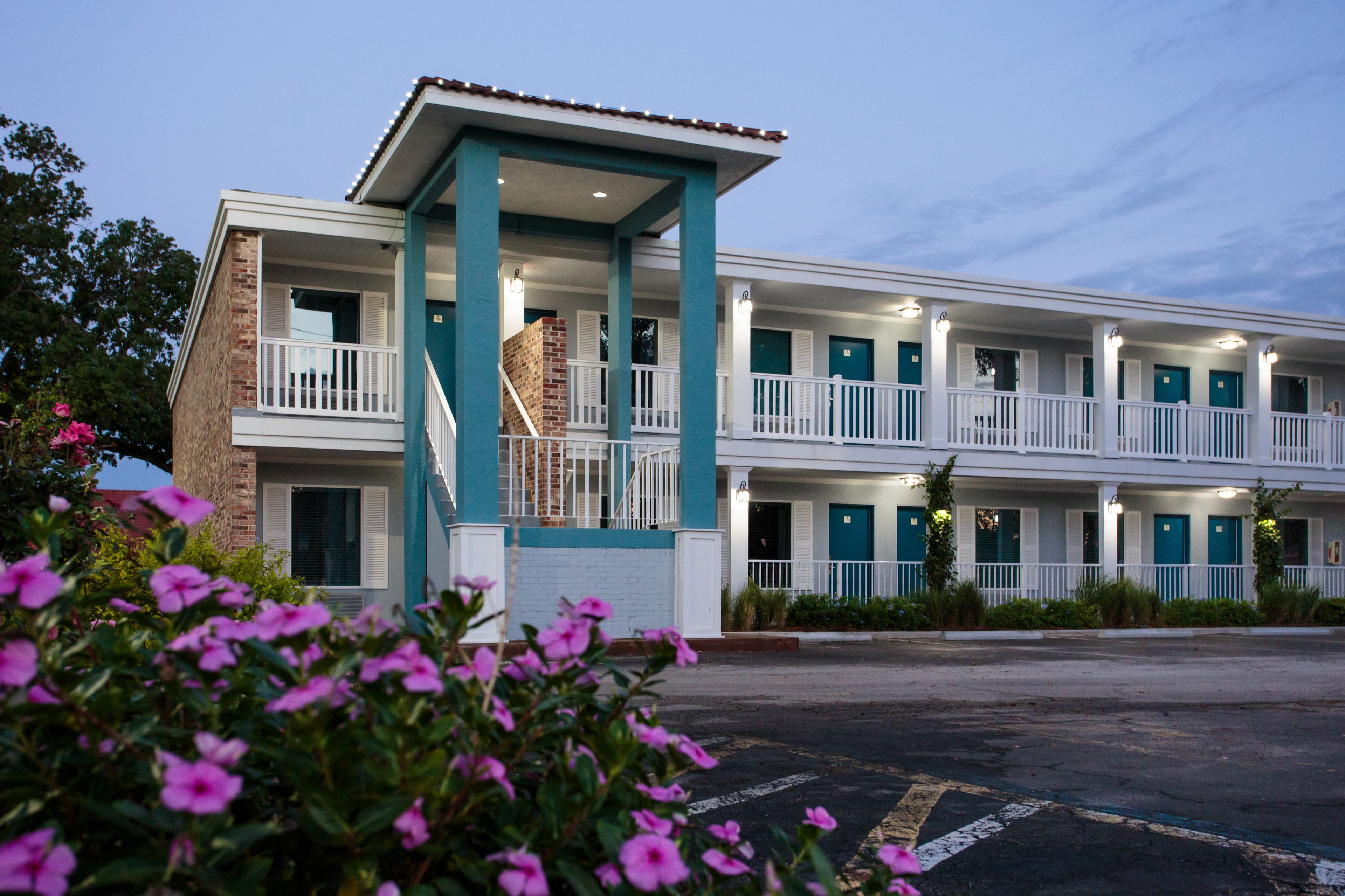 Un motel composé d’un bâtiment à deux étages, d’un porche avant couvert et d’une cheminée en briques.
